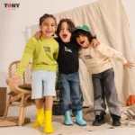 تيشيرت صيفي للأولاد من القطن بتصميم باريسي برقبة دائرية باللون الأخضر الليموني والأسود والكريمي، مزين بنصوص بارزة ورقعة على الكم.