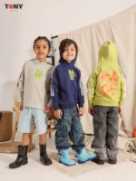 هودي صيفي للأولاد من القطن، بلون بيج وكحلي وأخضر ليموني، مزين برسومات نيون وخطوط على الأكمام.